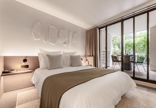 une chambre avec un grand lit et une grande fenêtre dans l'établissement Luxury Residence in old Marais, 3 BR, Patio, Sauna, Fitness Room, AC, à Paris