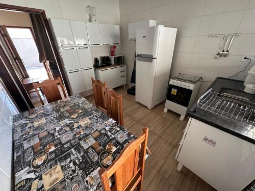 a kitchen with a table and chairs and a refrigerator at Casa de Temporada Olímpia 12 Pessoas in Olímpia