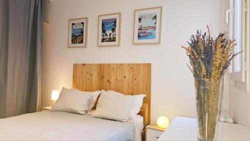 - une chambre avec un lit et un vase de fleurs dans l'établissement Charmant T2 au coeur de Sète avec terrasse !, à Sète