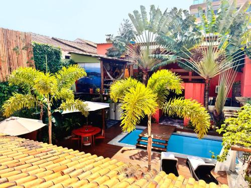 a patio with palm trees and a swimming pool at Pousada Arraial Inn in Arraial do Cabo