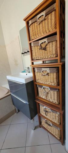 - un bureau avec des paniers et un lavabo dans la chambre dans l'établissement Appartement La Plage Plouha, à Plouha