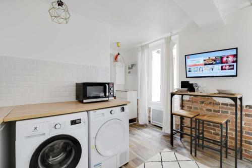 - une buanderie avec un lave-linge et une télévision dans l'établissement Charming studio - 2P - Center of Paris, à Paris