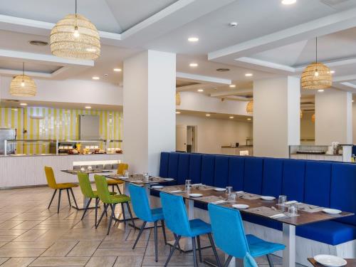 a dining room with blue chairs and tables at Alua Atlantico Golf - All Inclusive in San Miguel de Abona