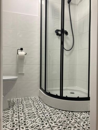 a bathroom with a shower and a tiled floor at Nowe studio blisko Atlas Areny in Łódź