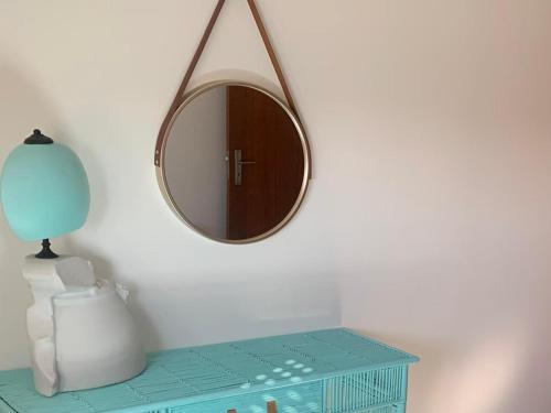 a mirror on a wall next to a table at Your sweet home near Aveiro! in Marco da Oliveirinha