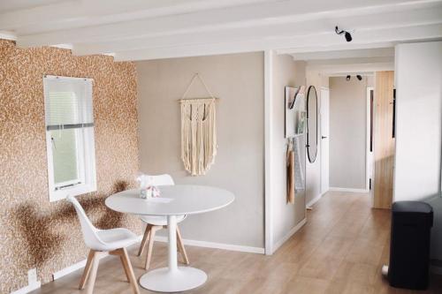 ein Esszimmer mit einem weißen Tisch und Stühlen in der Unterkunft Heerlijk huisje op de Veluwe in Putten in Putten
