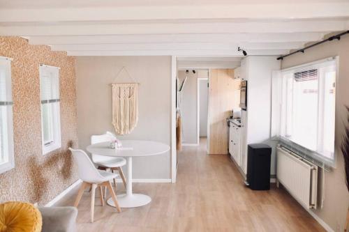 ein Wohnzimmer mit einem weißen Tisch und Stühlen in der Unterkunft Heerlijk huisje op de Veluwe in Putten in Putten