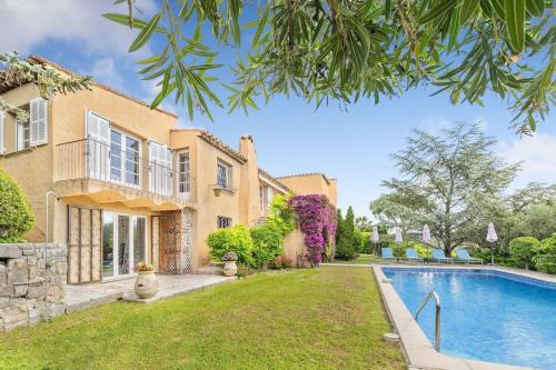 une maison avec une piscine en face d'une cour dans l'établissement Superbe villa provençale climatisée, piscine et jardin à Mougins Village, à Mougins