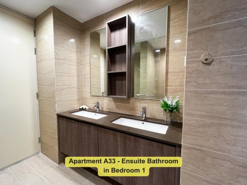 a bathroom with two sinks and a mirror at By the Sea- Pool and Sea View in Batu Ferringhi