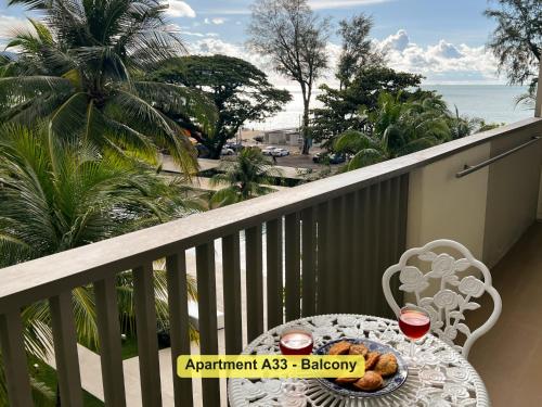 a table with a plate of food on a balcony at By the Sea- Pool and Sea View in Batu Ferringhi