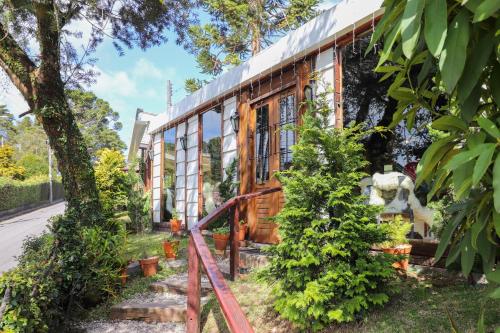 a house with a gate and trees at Pousada Campos do Jordao Suites in Campos do Jordão