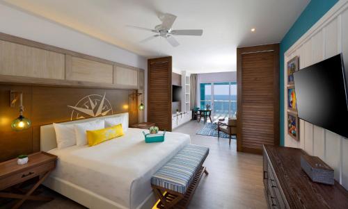 a bedroom with a large bed and a television at Margaritaville Island Reserve Riviera Maya - An Adults Only Karisma All-Inclusive Experience in Puerto Morelos