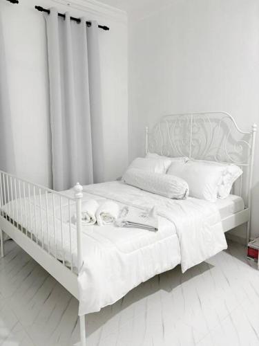 a white bed with a book on it in a room at Rayyan Homestay in Pasir Puteh