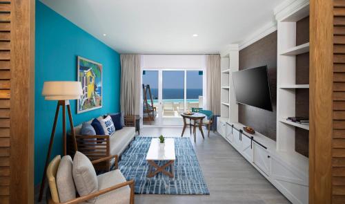 a living room with a couch and a tv at Margaritaville Island Reserve Riviera Maya - An Adults Only Karisma All-Inclusive Experience in Puerto Morelos