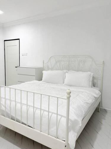 a white bed with white sheets and pillows at Rayyan Homestay in Pasir Puteh