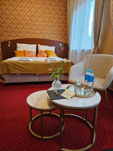 a hotel room with a bed and a table with drinks on it at Hotel Galicja SPA Wieliczka in Wieliczka