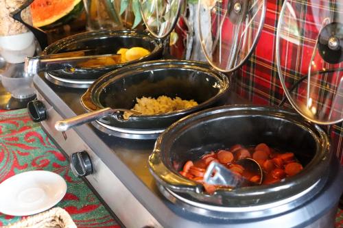 three pans of food sitting on top of a stove at Pousada Campos do Jordao Suites in Campos do Jordão