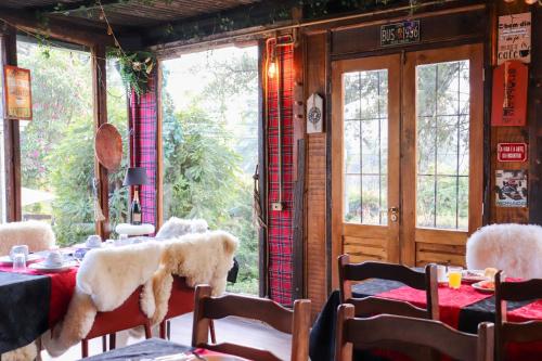 a dining room with tables and chairs and windows at Pousada Campos do Jordao Suites in Campos do Jordão