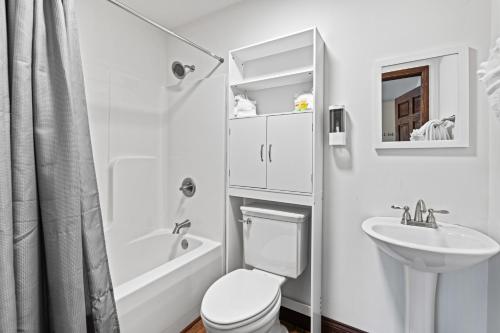 a white bathroom with a toilet and a sink at Utopian Bliss in Sevierville