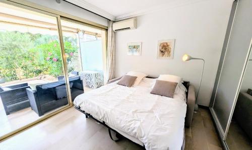 une chambre avec un lit et une grande fenêtre dans l'établissement Ref SOPHIA by Palmes dProperties, à Cannes