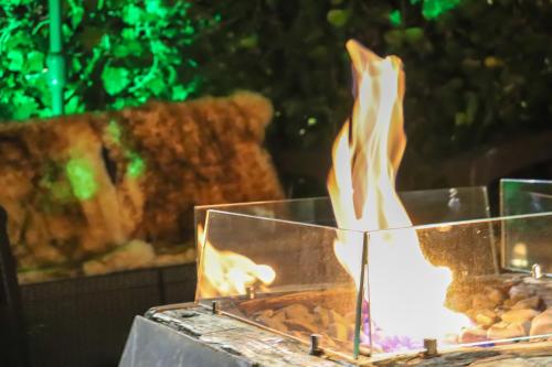 a fire in a glass box with food in it at Pousada Campos do Jordao Suites in Campos do Jordão