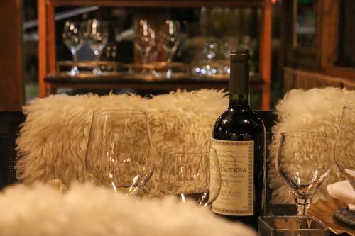 a bottle of wine sitting on a table with wine glasses at Pousada Campos do Jordao Suites in Campos do Jordão