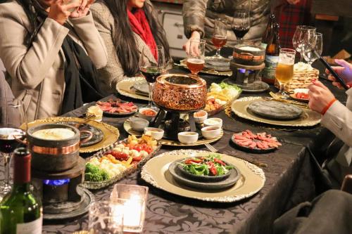 a group of people standing around a table with food at Pousada Campos do Jordao Suites in Campos do Jordão