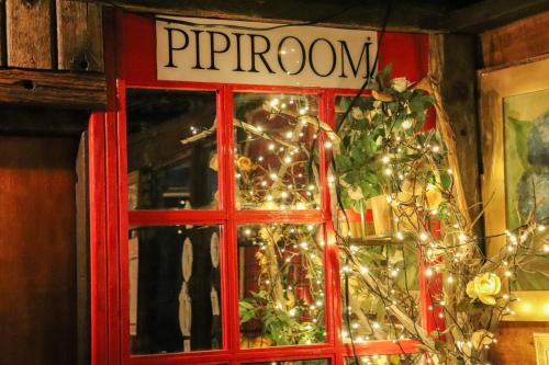 a red door with a christmas tree and lights at Pousada Campos do Jordao Suites in Campos do Jordão