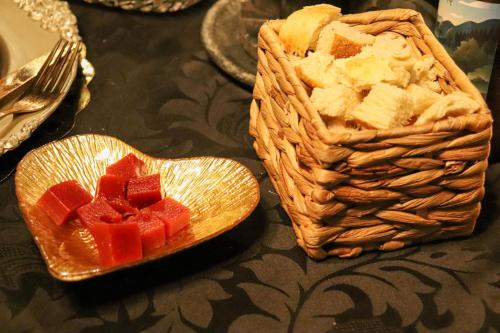 a bowl of diced fruit and a basket of bread at Pousada Campos do Jordao Suites in Campos do Jordão