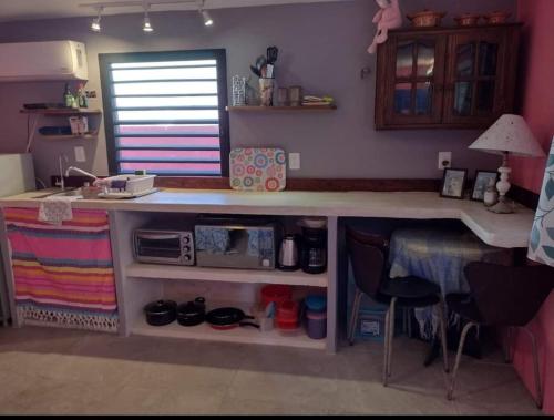 a kitchen with a counter and a desk with a table at Courtyard family room in Chelem