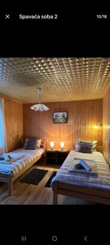 two beds in a room with wood paneled walls at Kuća za odmor ,Erdelj 21 B in Generalski Stol