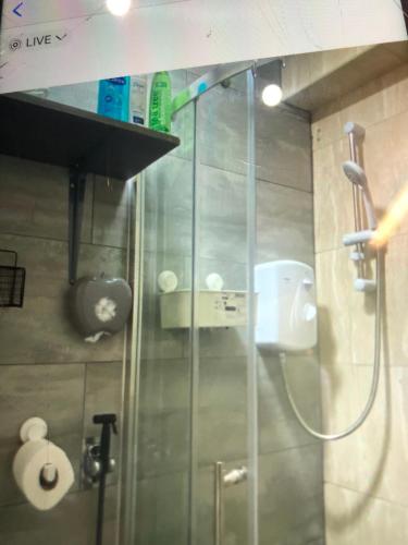 a shower with a glass door in a bathroom at Blue Room, twin in London