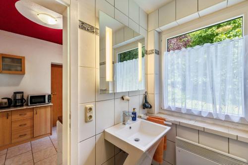a bathroom with a sink and a window at Ferienwohnung am Wald in Hagenow