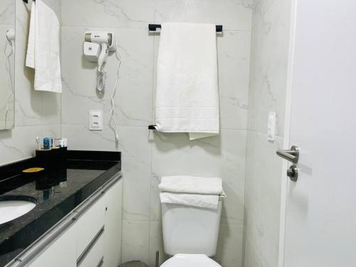 ein weißes Badezimmer mit Toilette und Waschbecken in der Unterkunft Oàsis à beira mar-Porto City 201 in Porto De Galinhas