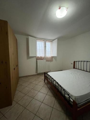a bedroom with a bed and two windows at CentoMetri Open in San Massimo