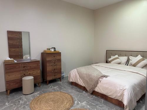 a bedroom with a bed and a dresser and a mirror at AL- aqyr Rest Garden أستراحة حارة العقر in Nizwa
