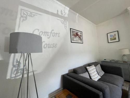 a living room with a couch and a lamp at Entire 8 Ensuite Bedroom Coastal Holiday Home Townhouse, Free Parking, Fully Equipped Kitchen, Dining Room & Lounge, Perfect for Family Gatherings, Long Term Contractor, Relocation, etc Stays, 20 mins to Sunderland & Newcastle, See our Site for Assurance in South Shields