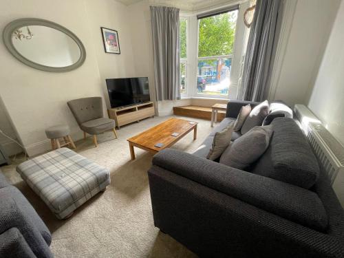 a living room with a couch and a table at Entire 8 Ensuite Bedroom Coastal Holiday Home Townhouse, Free Parking, Fully Equipped Kitchen, Dining Room & Lounge, Perfect for Family Gatherings, Long Term Contractor, Relocation, etc Stays, 20 mins to Sunderland & Newcastle, See our Site for Assurance in South Shields