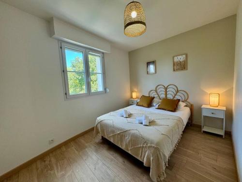 une chambre avec un lit avec deux lampes et une fenêtre dans l'établissement Le Botanica, grand T2 à Rennes, à Les Gaudinais