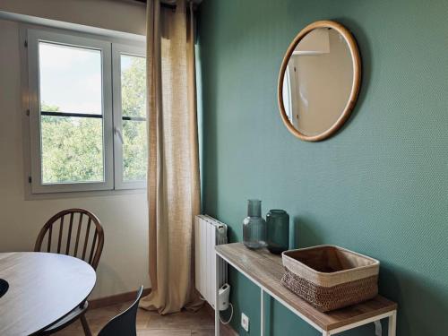 Cette chambre comprend une table et un miroir mural. dans l'établissement Le Botanica, grand T2 à Rennes, à Les Gaudinais