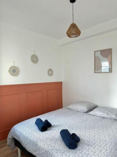 une chambre avec un lit avec des serviettes bleues dessus dans l'établissement Le Perchoir de la Gare - Blois, à Blois