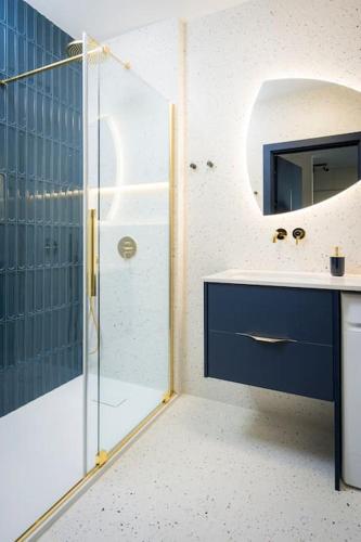 a bathroom with a shower and a sink and a mirror at Centaurus 144 by RENT4YOU in Olsztyn