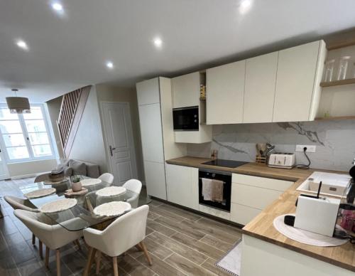 une cuisine et un salon avec une table et des chaises dans l'établissement Granville / Maison entièrement rénovée à 100 m des plages, à Granville