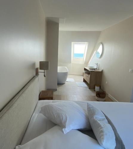 - une chambre blanche avec un lit et une salle de bains dans l'établissement Granville / Maison entièrement rénovée à 100 m des plages, à Granville