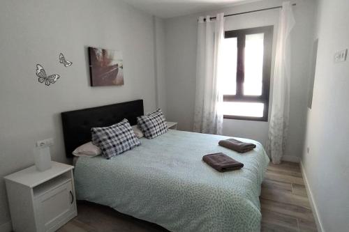 a bedroom with a bed with two pillows and a window at Apartamento Refugió del Mar in El Médano