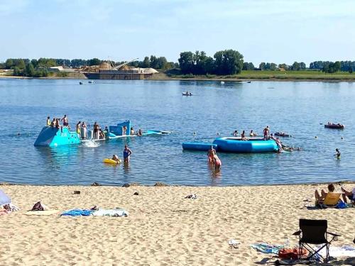 a group of people in the water at a beach at Vakantiehuis met vijverzicht in Lathum