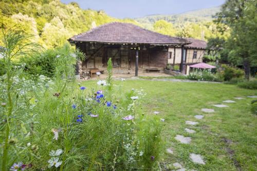a garden with a pavilion and flowers in a yard at Little River Guest House in Gabrovo