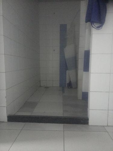 a bathroom with white tiled walls and a blue and white floor at Casa verde in Monjolo