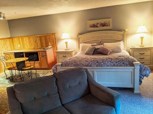 una camera da letto con un letto grande e un divano di Springbrook Inn East Room a Houghton Lake