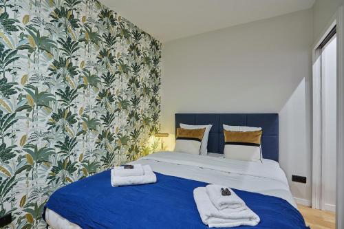 une chambre avec un lit bleu avec des serviettes dessus dans l'établissement Apartment in the Center of Paris by studioprestige, à Paris